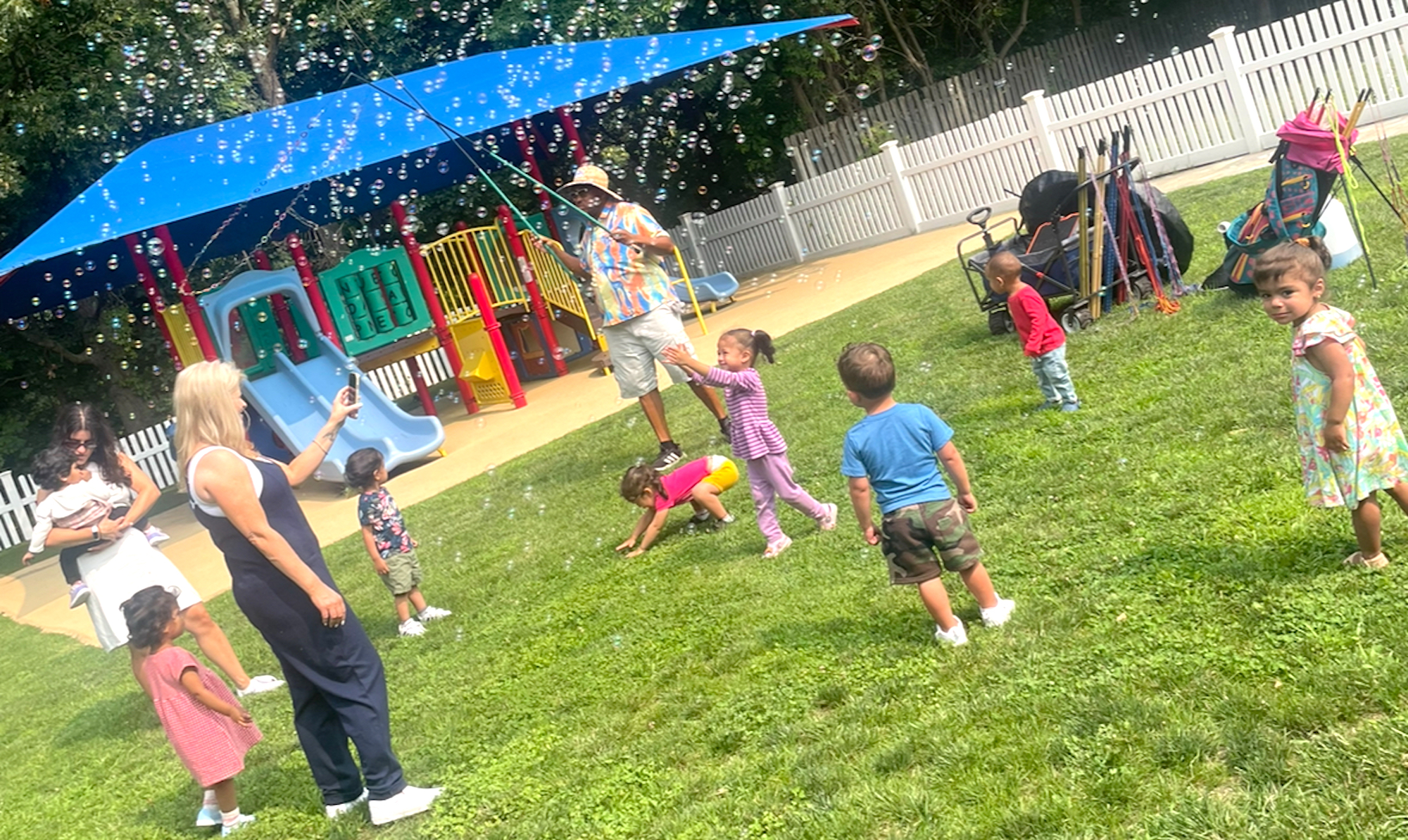 Children laughing and playing together outdoors at The Peace Rose Montessori School